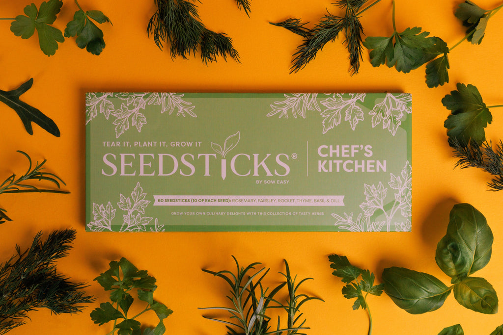 Chef’s Kitchen Seedsticks gift bar surrounded by fresh culinary herbs