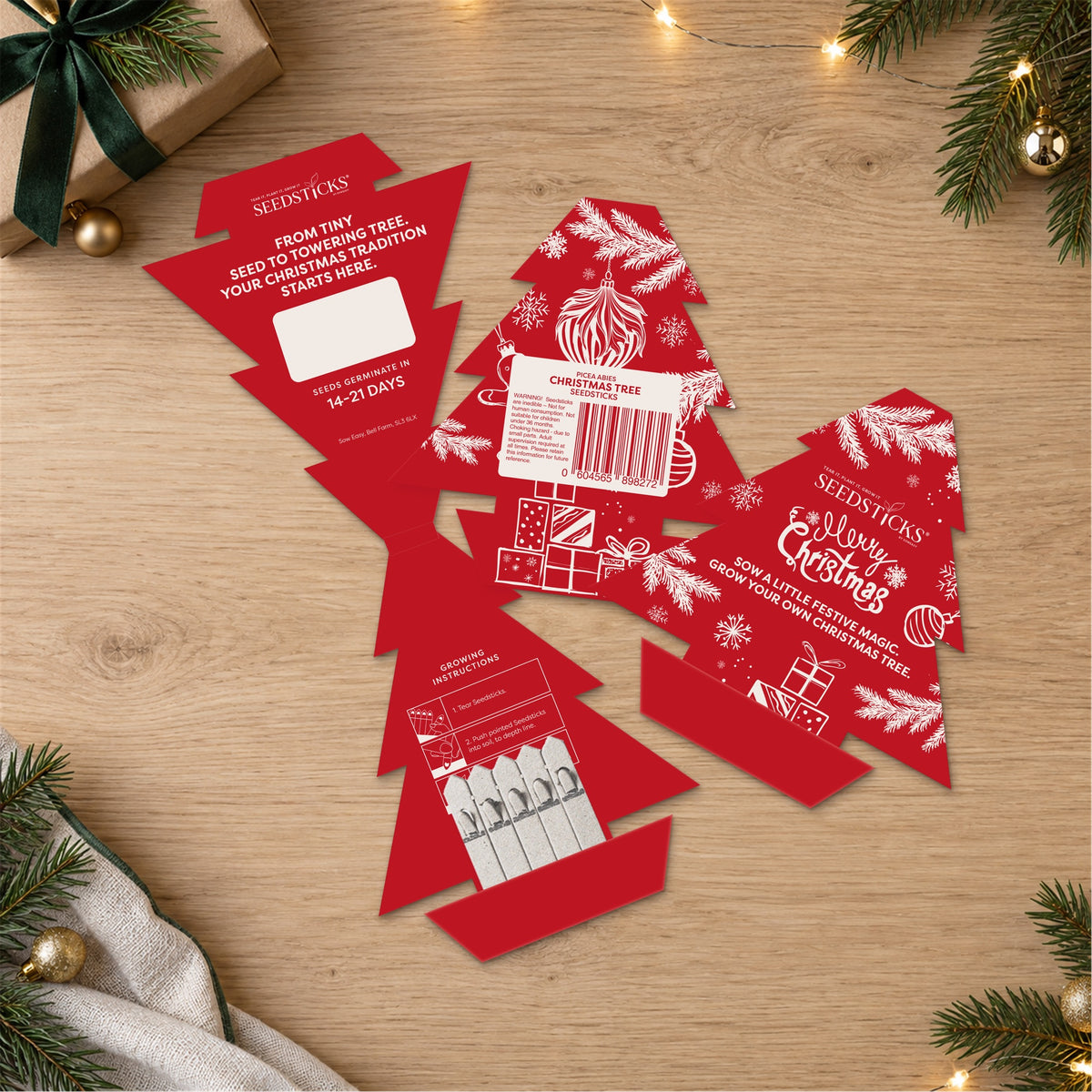 Christmas Tree Seedsticks packs and planting sticks arranged in a festive setting